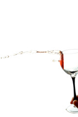 stream of wine being horizontal pouring from the glass isolated on the white background
