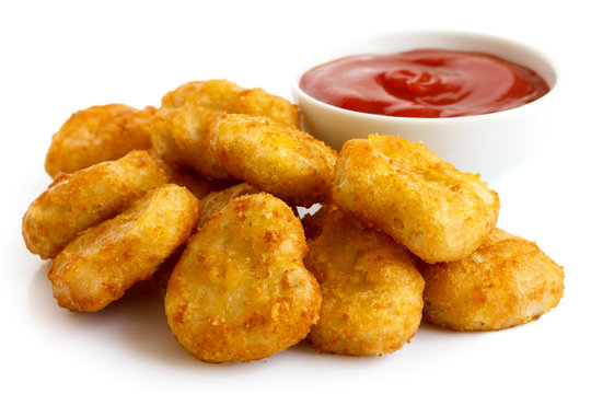 Pile of golden deep-fried battered chicken nuggets with bowl of - Powered by Adobe
