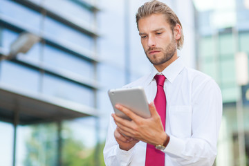 Blonde businessman using a tablet pc