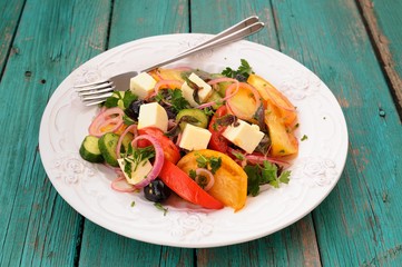 Greek salad with fresh vegetables and feta cheese in large white