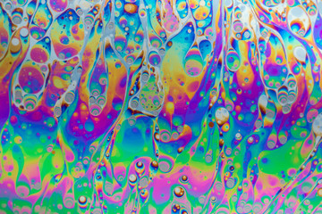 Multicolored soap bubble abstract background formed by light reflecting off the surface of a soap...