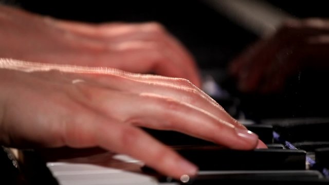 Two hands playing  on a beautiful grand piano.