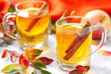 Hot drink with apple juice, lemon and cinnamon in autumn