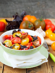 salad of colorful tomatoes on a wooden background