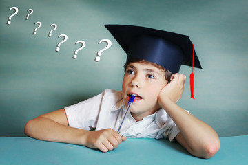 boy in graduation cap think about school subject