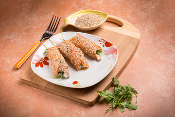 salmon rolled up with sesame seeds ricotta and arugula