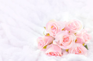 Obraz na płótnie Canvas Pastel Coloured Artificial Pink Rose on white fur background