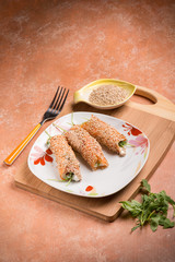 salmon rolled up with sesame seeds ricotta and arugula