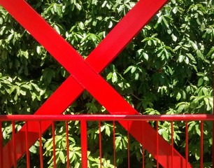 Estrutura metálica vermelha em meio as folhas