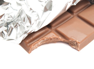 tiles of milk chocolate in a foil on white