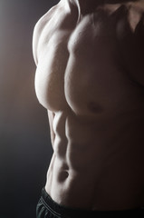 Muscular man posing in dark studio