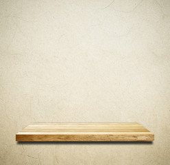 Empty wooden shelf over grunge cement wall background