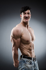 Fototapeta na wymiar Muscular man posing in dark studio