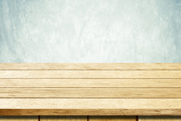 Empty wooden table over grunge cement wall background