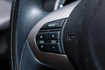 Audio control buttons on the steering wheel of a modern car
