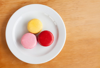 Sweet and colourful french macarons on wood background
