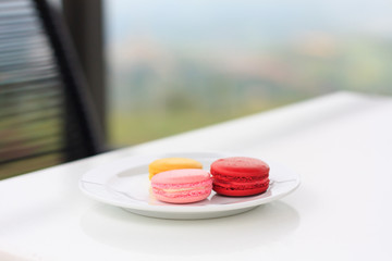 Sweet and colourful french macarons on white table