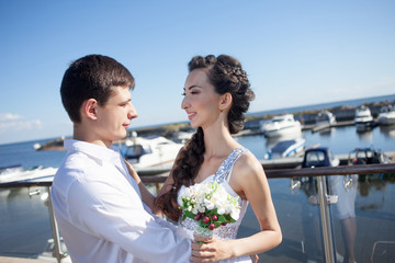 Naklejka premium bride and groom on the background of yacht club, young happy
