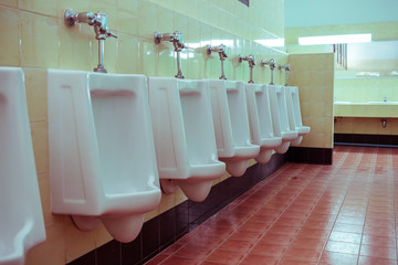 row white urinals in men's bathroom toilet
