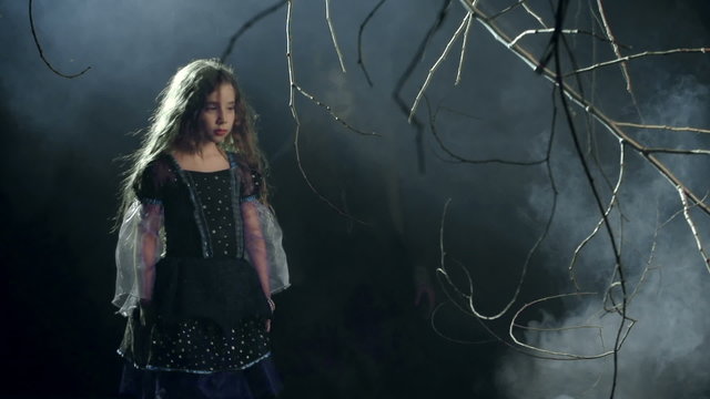 Little girl being caught by devil woman in misty forest 