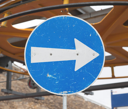 Blue road sign with white arrow pointing right