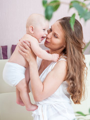 Mother and baby playing and smiling. Happy family.Home interior.