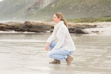 Woman crouching at the shore