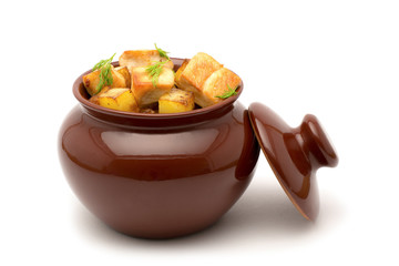 Fried potatoes with chunks of meat in a clay pot on isolated a white background