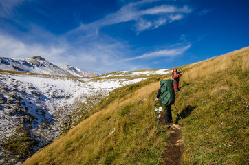 Fototapeta premium Two tourists with backpacks go to the mountains.