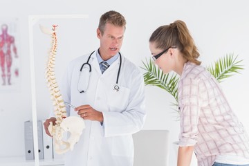 Doctor explaining anatomical spine to his patient 