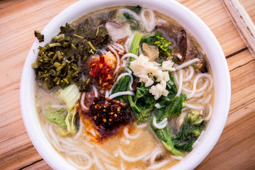 China noodle with mustard leaf and flavor on top.