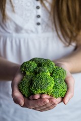 Fototapeta na wymiar Woman showing fresh green brocolli