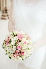 wedding bouquet of roses in hands of the bride