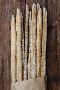 Rustic italian breadsticks on wooden background.