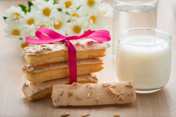 Close up. Puff pastry topping with sugar and nut, with milk glas