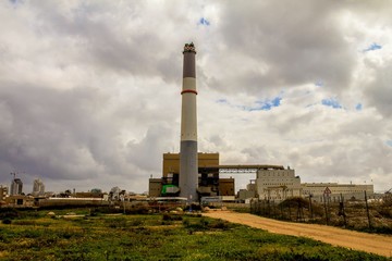 Small power plant using gas on dark stormy cloudy sky background