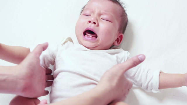 Mothercare, young mother calms her newborn baby during she is crying and screaming