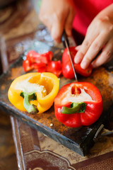 female's hand cutting big chilli peper