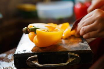 female's hand cutting big chilli peper