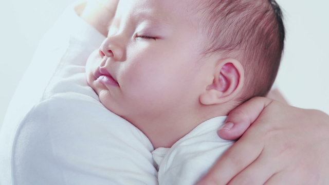Side view of a woman with baby sleeping on her shoulder. Isolate on white background.