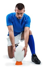 Full length of rugby player placing ball