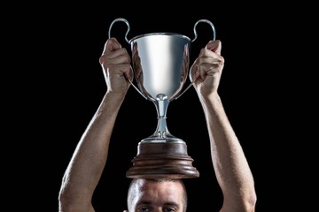 Fototapeta na wymiar Successful rugby player holding trophy