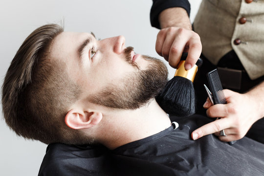 Barber cleaning face of his brutal customer with brush