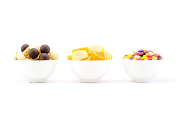 Three bowls of sweets and chocolate jelly mushrooms isolated on white background