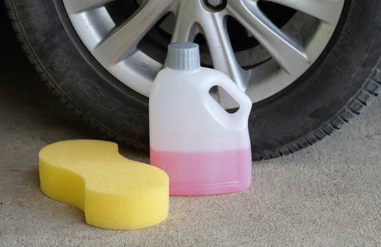 cleaning shampoo and sponge on car tire background