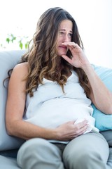 Pregnant woman crying at home