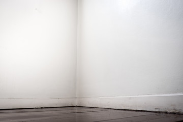 Empty white wall and dark brown parquet floor in perspective vie