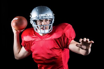 Determined American football player throwing ball