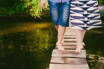 Fashionable cool couple on a bridge near the water, relationships, romance, legs, lifestyle - concept