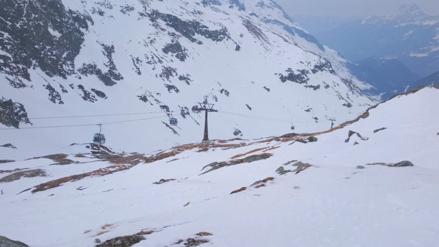 Cable cars moving at ski resort. Mountains covered with snow, winter landscape